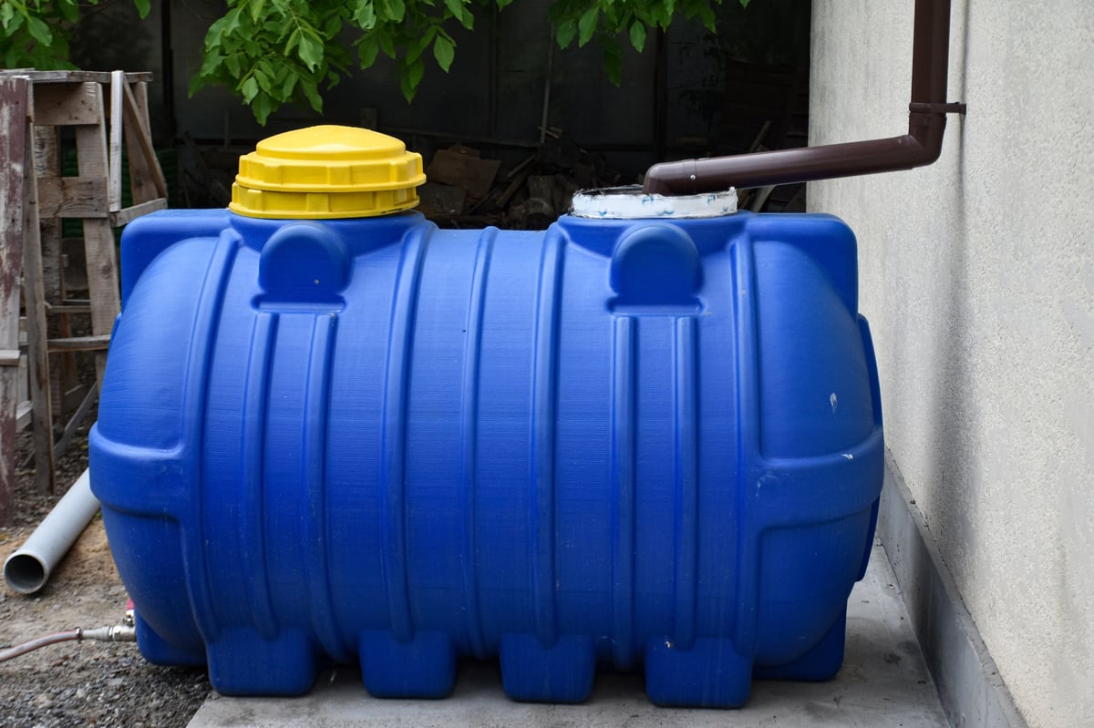 Large water storage tank connected to a downspout for rainwater collection